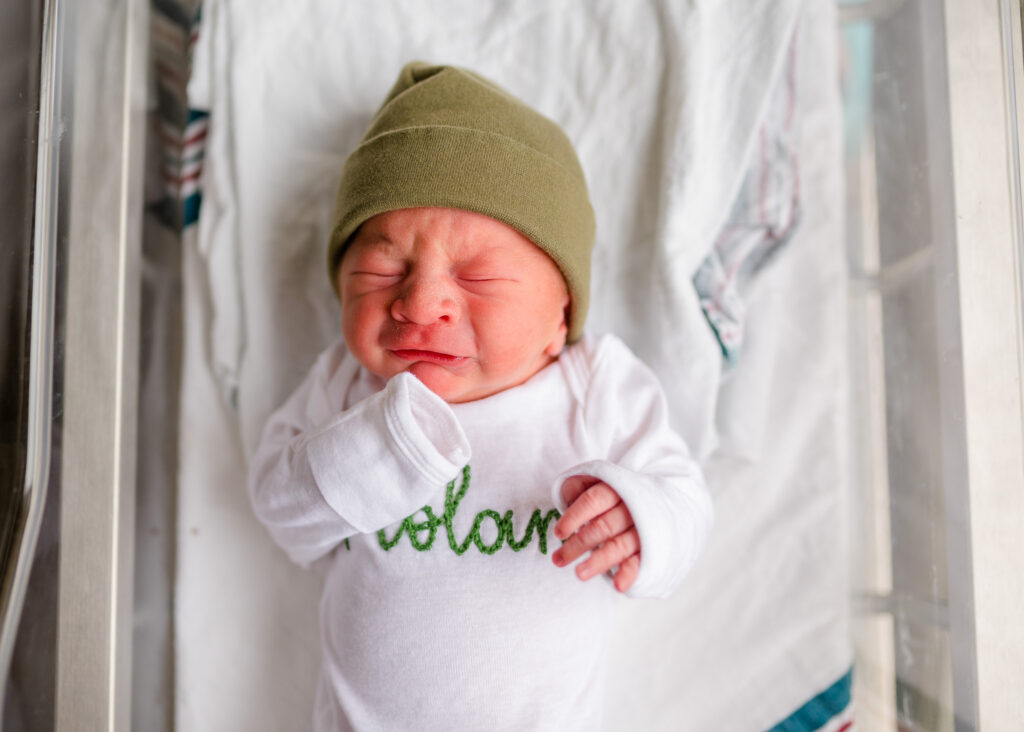 Fresh 48 newborn with hat in monogrammed onesie