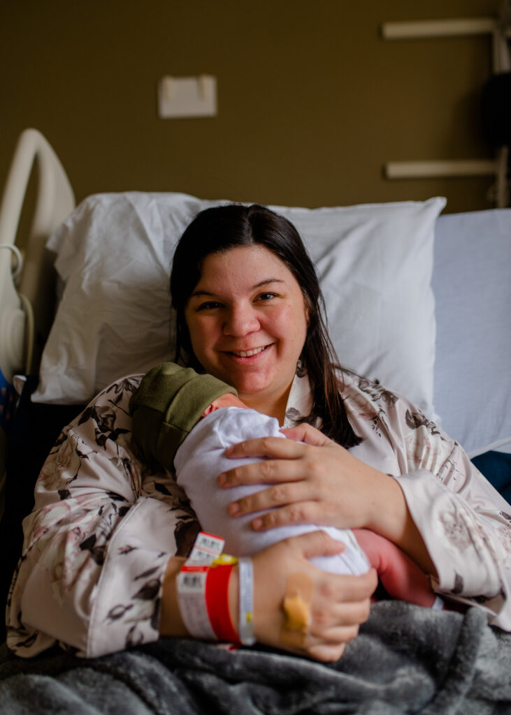 New mom all smiles holding her newborn baby
