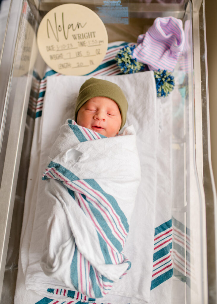 Fresh 48 swaddled newborn in bassinet with hospital blanket